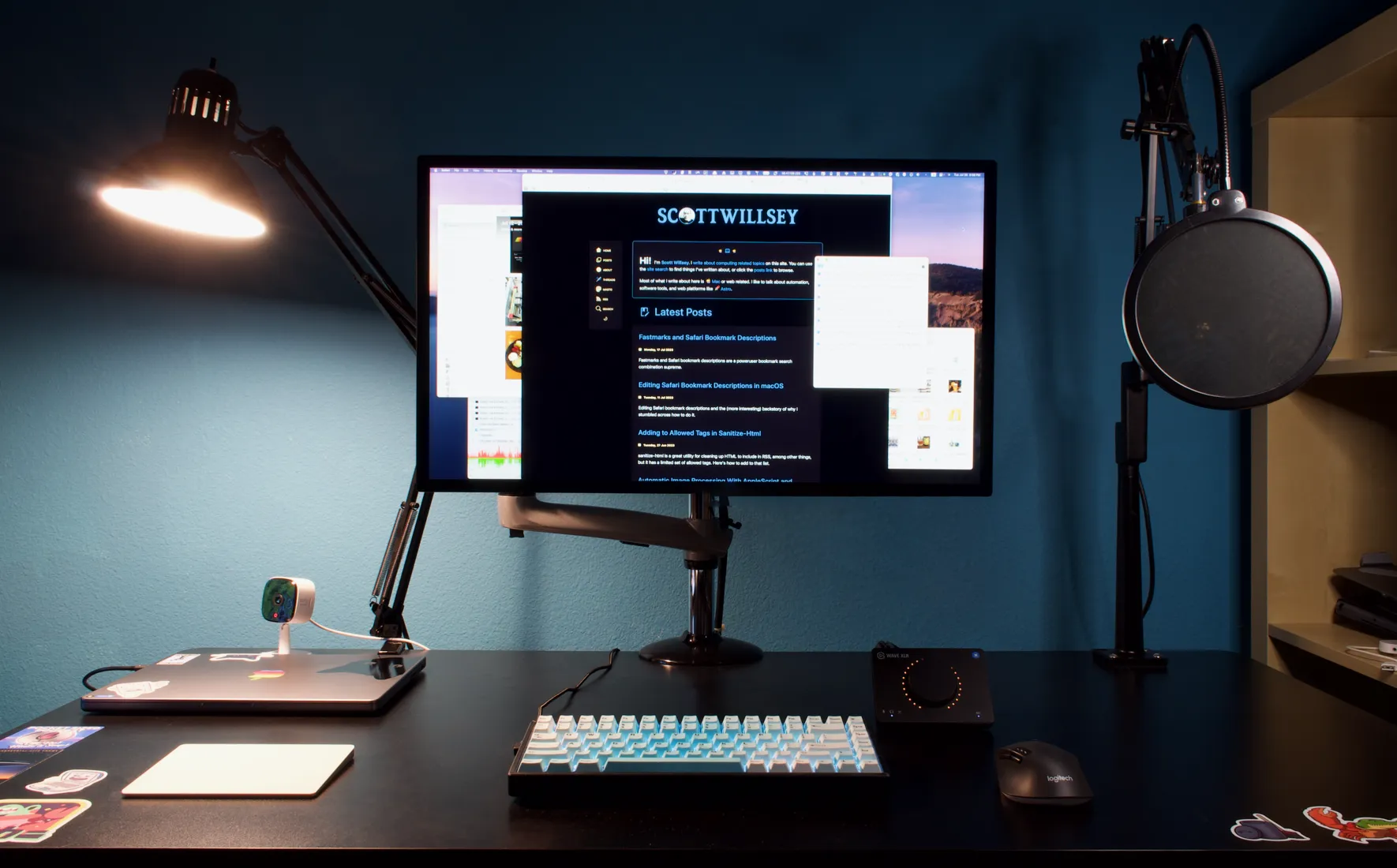 My computer desk with MacBook Pro, Studio Monitor, and accessories